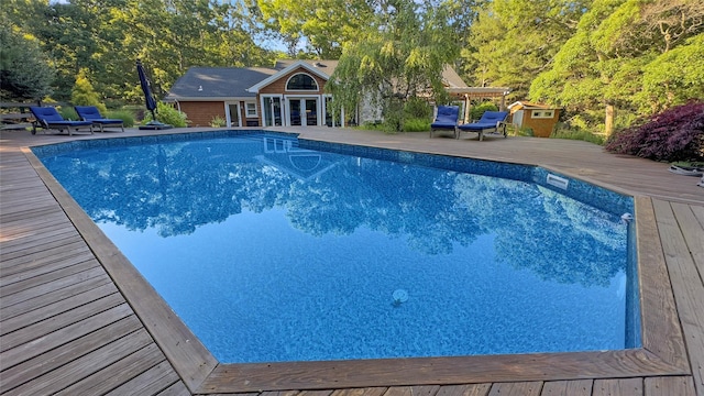 view of swimming pool with a wooden deck and an outdoor structure