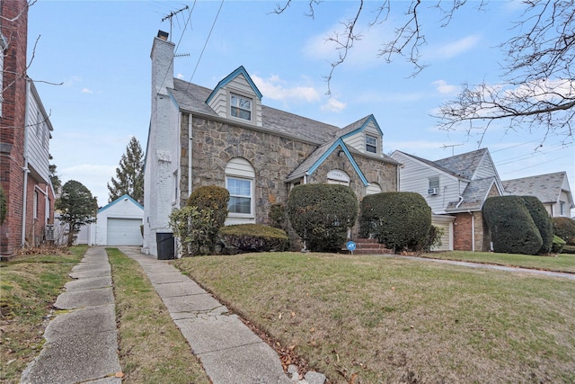 view of front of house with a front yard, an outbuilding, and a garage