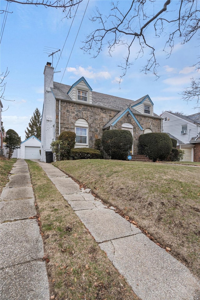 view of front of property with an outbuilding, a front yard, and a garage