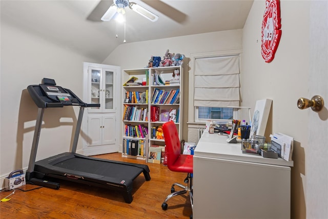 workout area featuring ceiling fan, hardwood / wood-style floors, and vaulted ceiling