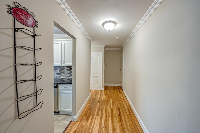 corridor featuring ornamental molding and light hardwood / wood-style floors