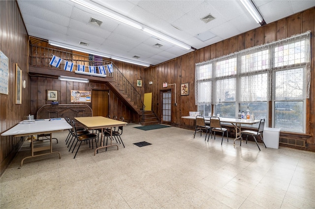 dining room featuring a wealth of natural light, wood walls, and a paneled ceiling