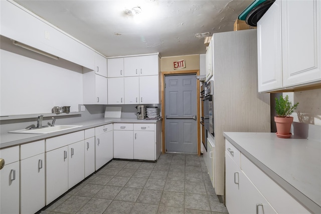 kitchen featuring white cabinetry, sink, and oven