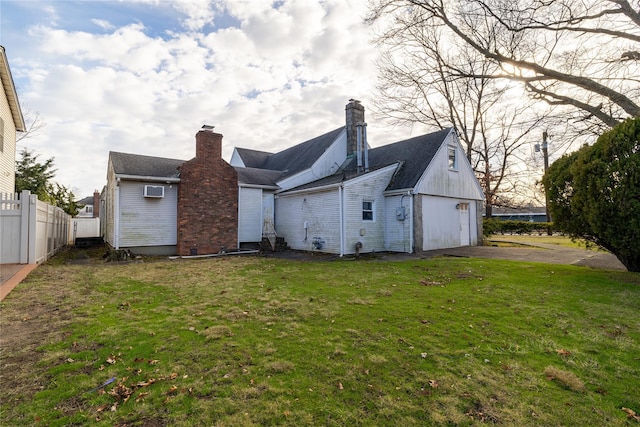 back of house featuring a lawn and a garage