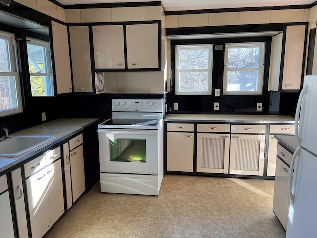 kitchen with sink, white appliances, range hood, and white cabinets