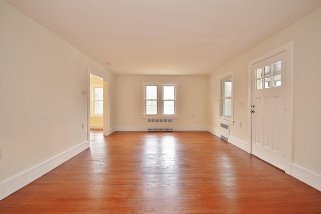 foyer entrance featuring radiator and light wood-type flooring