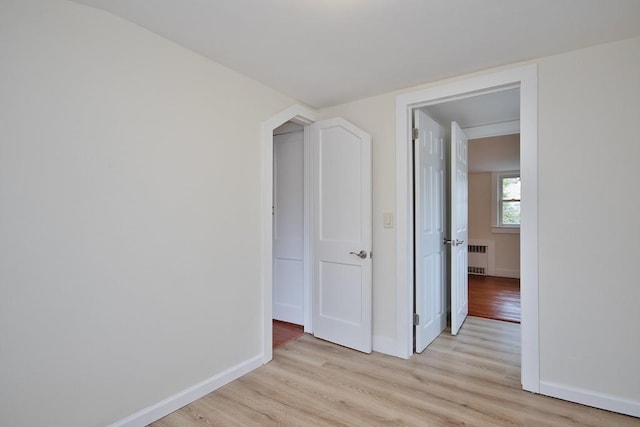 hall with radiator and light hardwood / wood-style floors