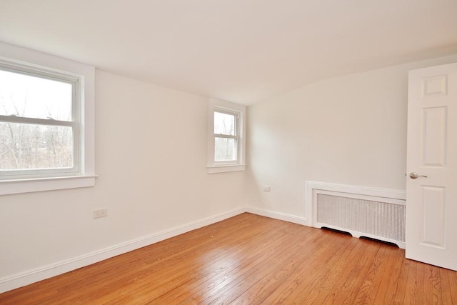 empty room featuring radiator and light hardwood / wood-style floors