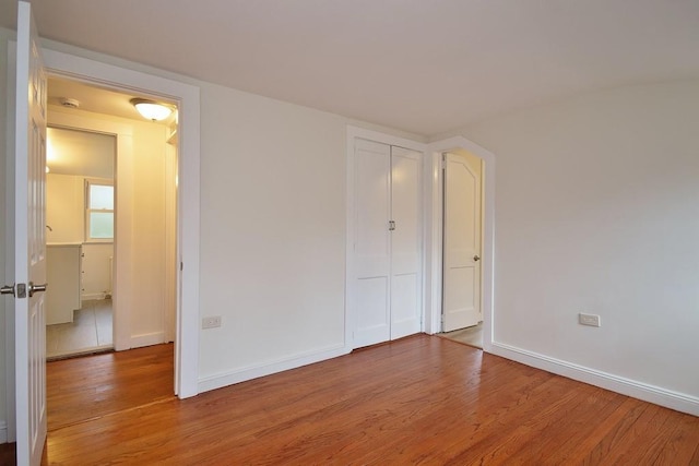 unfurnished bedroom with hardwood / wood-style flooring and a closet