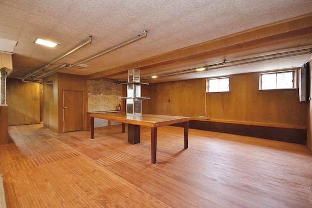 basement with hardwood / wood-style flooring and wood walls