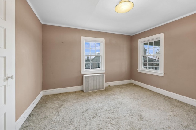 carpeted empty room featuring radiator heating unit and crown molding