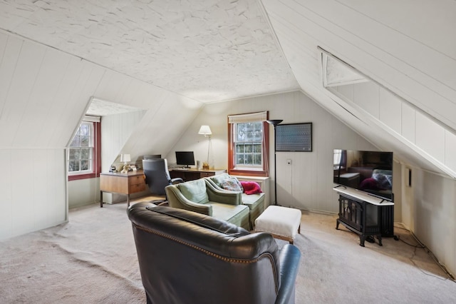 living room with light colored carpet, a wealth of natural light, a textured ceiling, and vaulted ceiling