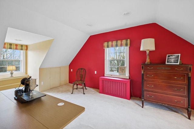 interior space with vaulted ceiling, light carpet, and radiator heating unit