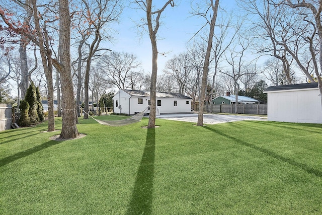 view of yard featuring a patio area, an outbuilding, and a pool