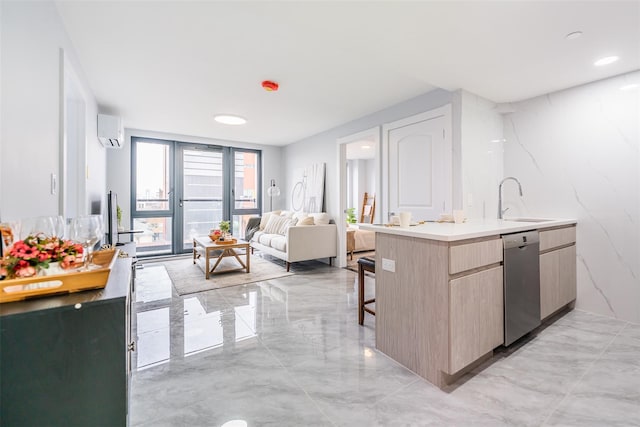 kitchen featuring a kitchen bar, light brown cabinetry, a wall unit AC, sink, and dishwasher