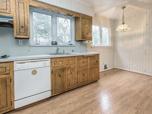 kitchen featuring a notable chandelier, light wood-type flooring, white appliances, hanging light fixtures, and sink