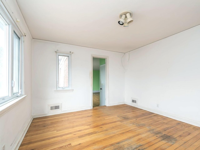 spare room with a wealth of natural light and light hardwood / wood-style floors