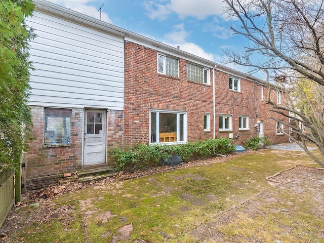 rear view of house featuring a yard