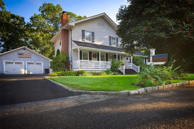 view of front of home featuring an outbuilding, a front lawn, covered porch, and a garage