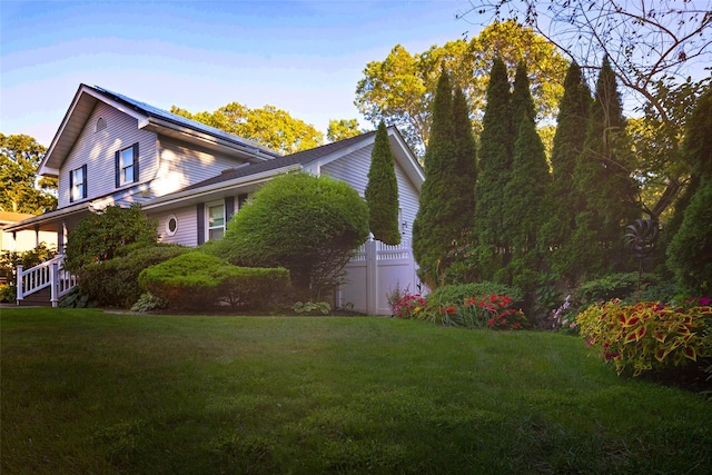 view of side of home with a yard