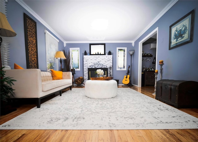 living room with crown molding, a fireplace, and hardwood / wood-style floors