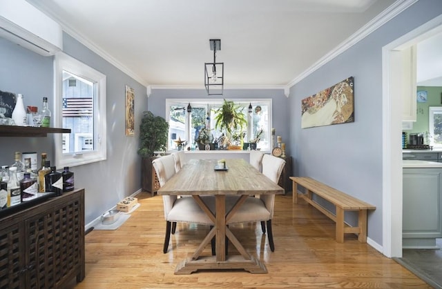 dining area with a wall mounted air conditioner, ornamental molding, and light wood-type flooring