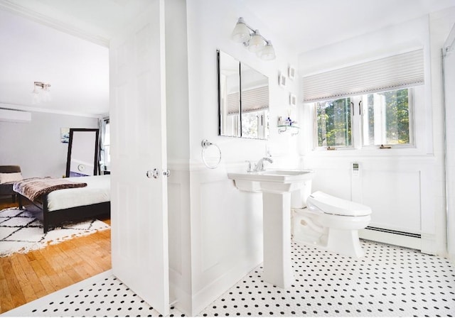 bathroom with a baseboard radiator, toilet, and crown molding