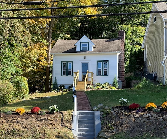 cape cod house with a front lawn