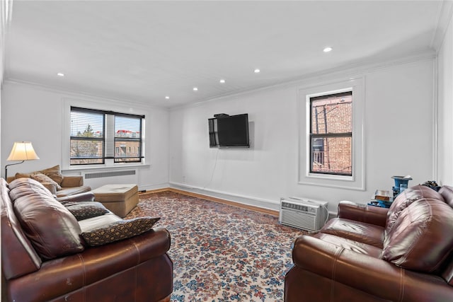 living room with an AC wall unit, wood-type flooring, and crown molding