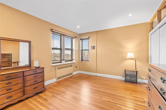 bedroom featuring radiator, a closet, and light hardwood / wood-style flooring