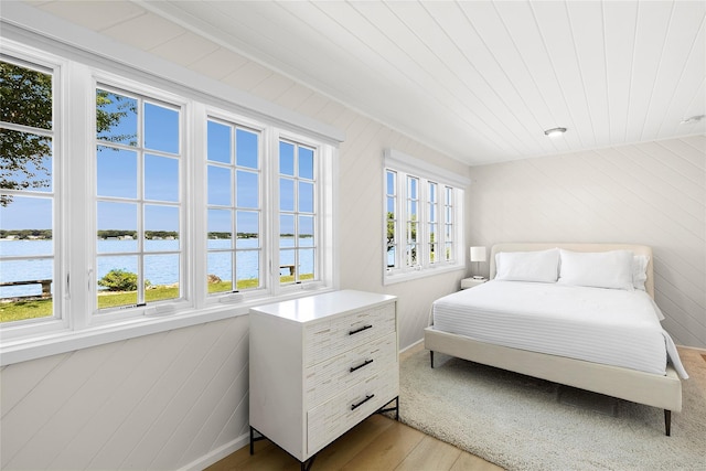 bedroom featuring a water view and wood-type flooring