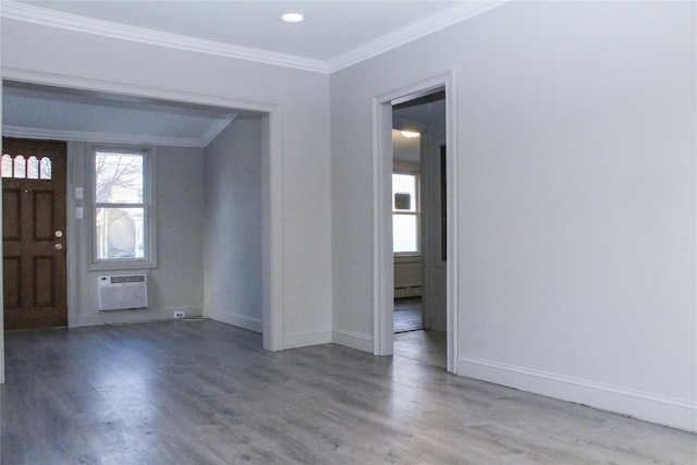 entryway featuring hardwood / wood-style flooring, baseboard heating, crown molding, and a wall unit AC