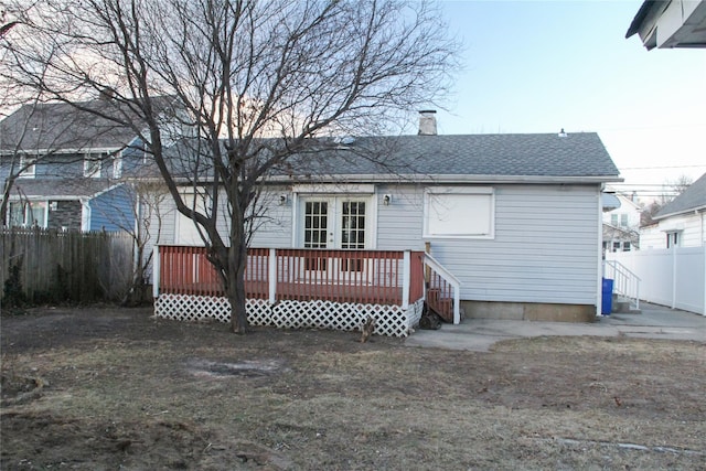 rear view of house featuring a wooden deck and french doors