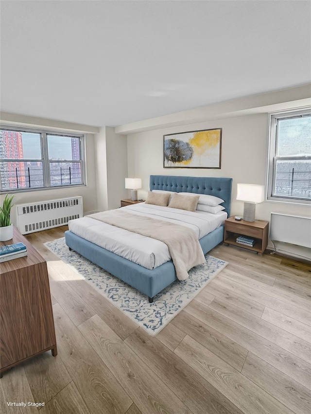 bedroom with radiator and light wood-type flooring