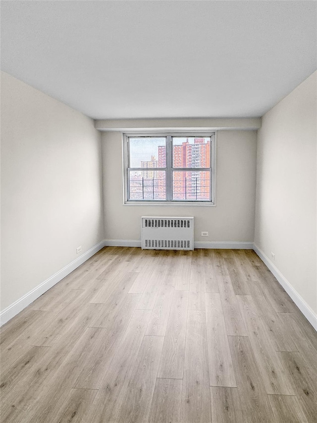 spare room with radiator and light hardwood / wood-style flooring