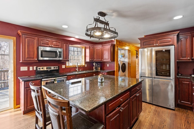 kitchen featuring dark brown cabinets, appliances with stainless steel finishes, and washing machine and clothes dryer