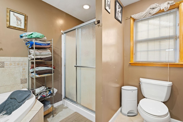 full bath featuring tile patterned flooring, a shower stall, baseboards, toilet, and a bath