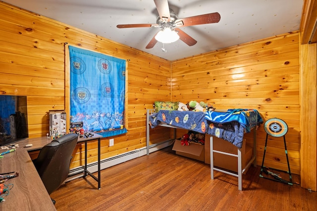 bedroom featuring hardwood / wood-style floors, wooden walls, and ceiling fan