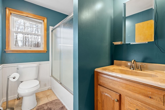 full bathroom featuring toilet, tile patterned flooring, vanity, and bath / shower combo with glass door