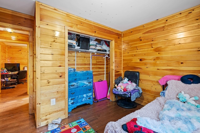 bedroom with wooden walls and wood finished floors