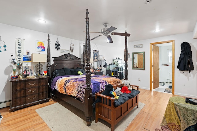 bedroom featuring recessed lighting, a baseboard heating unit, light wood-type flooring, and baseboards