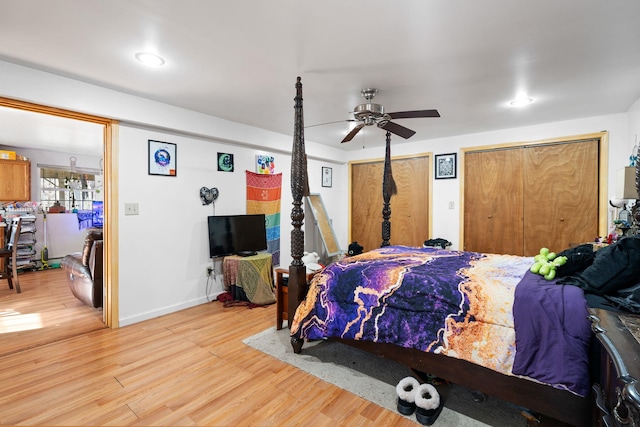 bedroom with two closets, ceiling fan, and light hardwood / wood-style floors