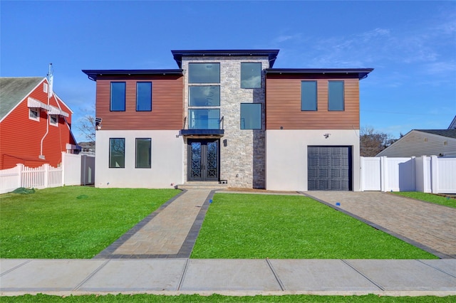 contemporary house featuring a front yard, french doors, and a garage