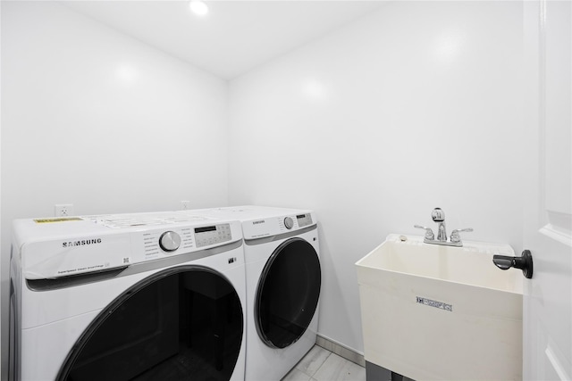 laundry room with sink, light tile patterned floors, and independent washer and dryer