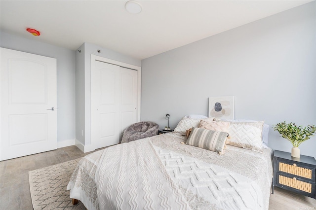 bedroom with light hardwood / wood-style flooring and a closet