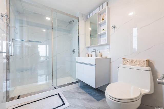 bathroom with vanity, toilet, a shower with door, and tile walls