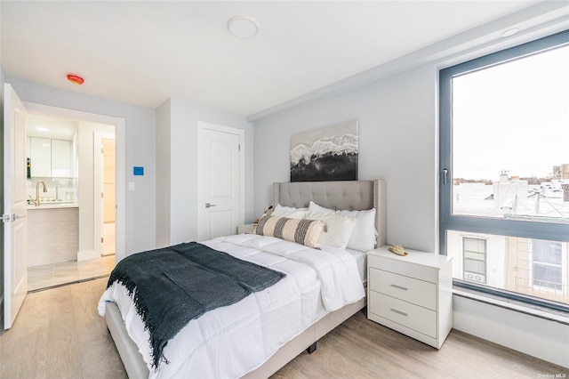 bedroom featuring sink and light wood-type flooring