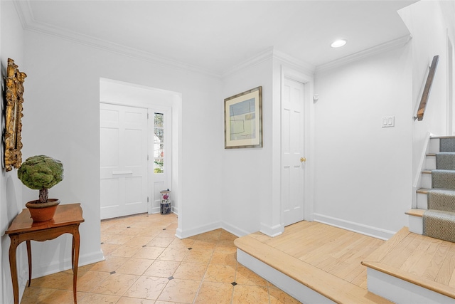 entryway with ornamental molding, baseboards, and stairs