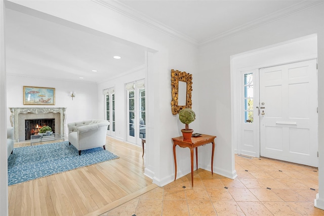 entrance foyer with plenty of natural light, a premium fireplace, and crown molding