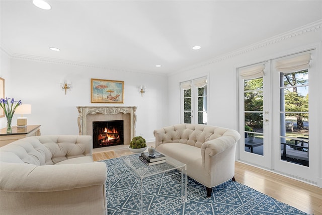 living area featuring ornamental molding, a premium fireplace, wood finished floors, and recessed lighting